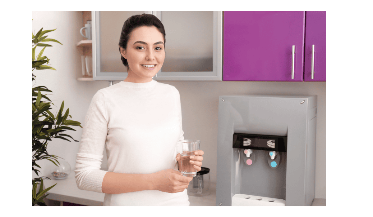 A woman with a glass of water and countertop dispenser