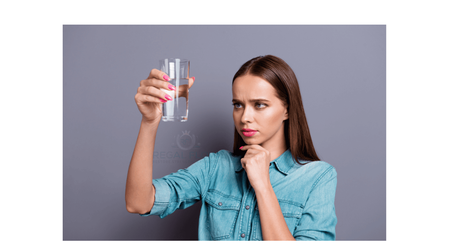Woman and a glass of reverse osmosis water and regal flow logo