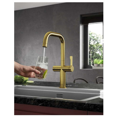 clearwater kitchen tap pouring water into a glass in brushed brass U spout