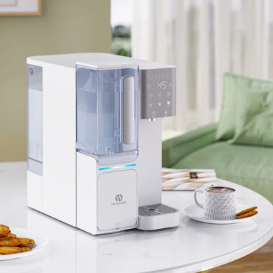 A Hommix countertop dispenser on a table with a cup of coffee and biscuits next to it
