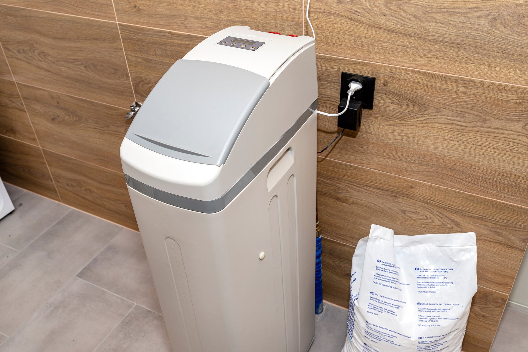 Home Water Softener plugged in with bag of salt next