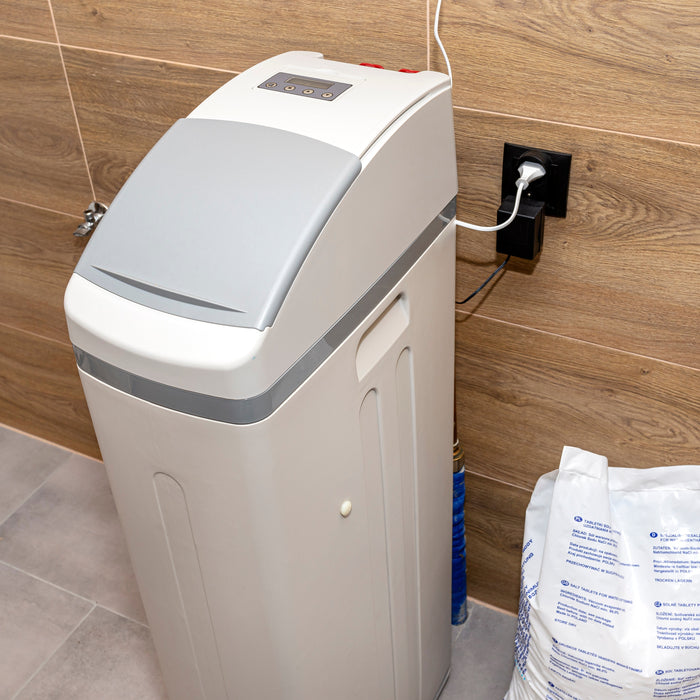 Home Water Softener plugged in with bag of salt next