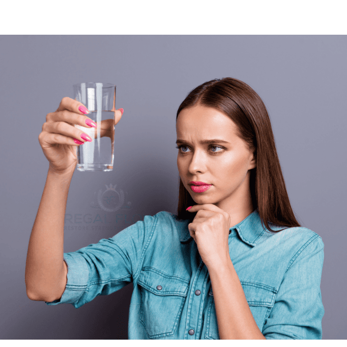 Woman and a glass of reverse osmosis water and regal flow logo
