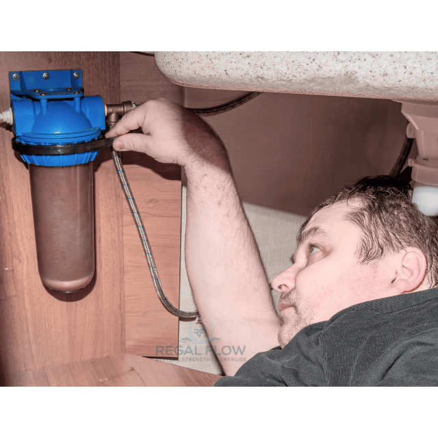 a man unscrewing a water filter with regal flow logo