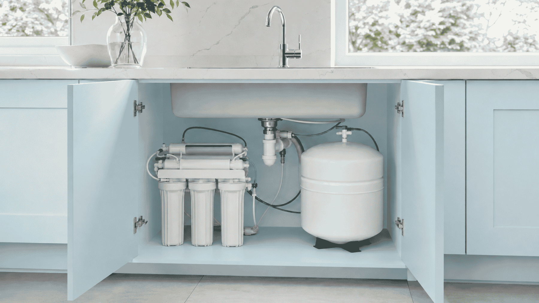 under sink water filter with tank in a blue kitchen with tap above
