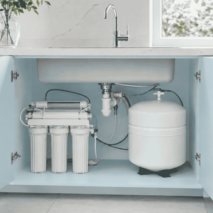 under sink water filter with tank in a blue kitchen with tap above
