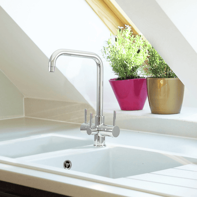 Acquapuro Monza chrome 3-way tap installed over white sink in bright kitchen