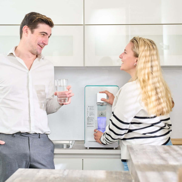 Couple enjoying fresh filtered hydrogen water from Ayus Wellness purifier at home