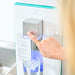 User pressing button to dispense water from the Ayus Wellness purifier
