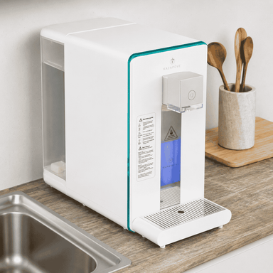 Countertop hydrogen water purifier on a work surface with wooden spoons in a holder