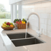 Modern kitchen 3 way faucet sink with running water, surrounded by fruits and vegetables on a light-colored countertop.