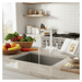 Modern kitchen with a sink, white triflow tap, fruits, vegetables, and kitchen utensils.