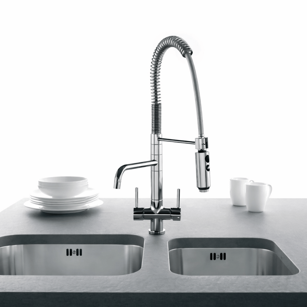 Chrome three way filter tap with pull out hose spray installed over a sink with coffee cups and plates