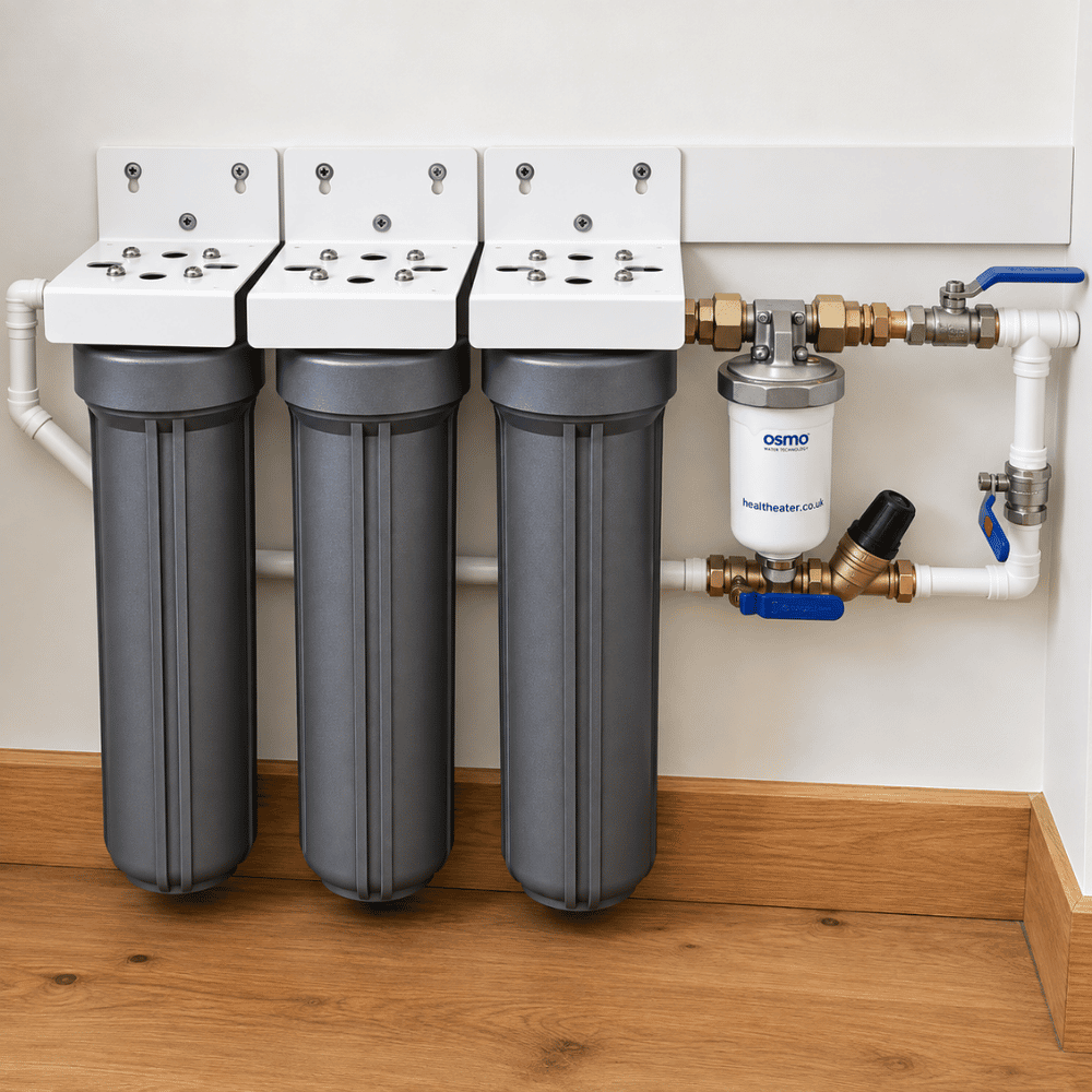 A whole house water system installed with 3 filter cartrigdes next to plumbing pipes