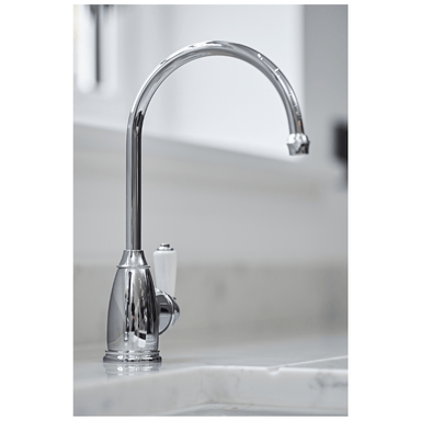 Hot water tap in Chrome on a marble countertop with a blurred background