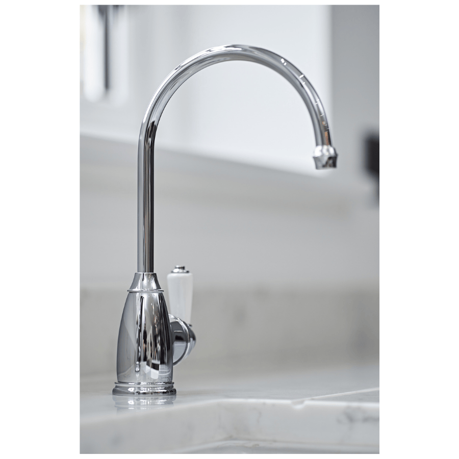Hot water tap in Chrome on a marble countertop with a blurred background